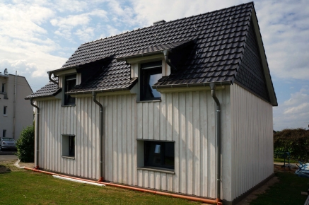 Fassadenverkleidung mit Holz in Boden-Deckel-Schalung